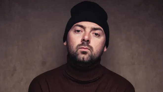 Михайло Клименко у светрі з городом та шапці