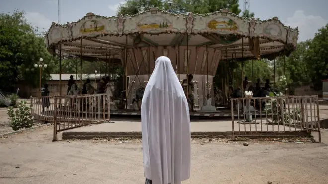 One girl wey dey watche other children as dem dey play for one abandon merry-go-round inside amusement park for Maiduguri, Nigeria.
