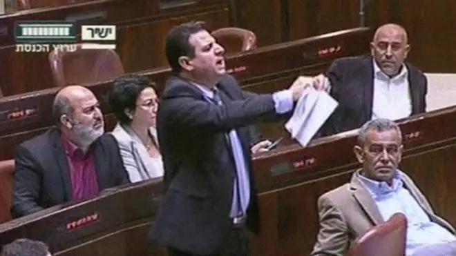 Anggota parlemen keturunan Arab Israel MP Ayman Odeh merobek salinan tagihan selama perdebatan sengit di Knesset