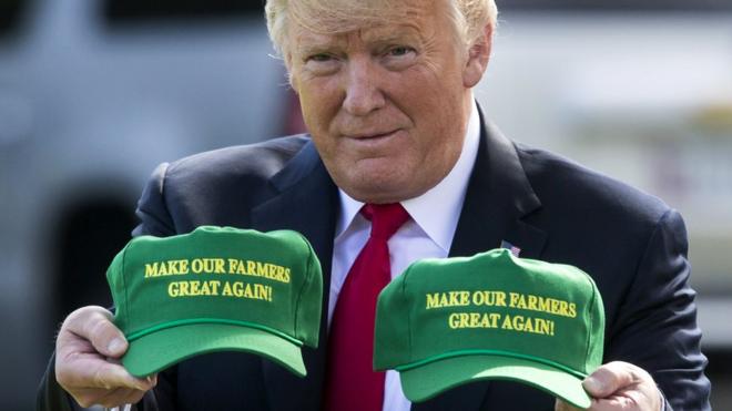US President Donald Trump displays hats that read: "Make Our Farmers Great Again!" at the White House, Washington DC, 30 August 2018