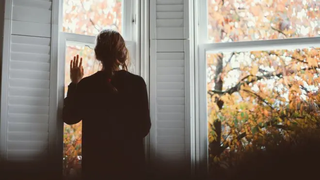 picture of lady looking out of a window
