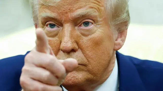 Лицо Дональда Трампа крупным планом, в кадре также видно его палец, указывающий в аудиторию