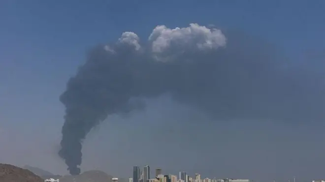 இரான் நடத்திய தாக்குதல்களுக்குப் பிறகு ஐக்கிய அரபு எமிரேட்ஸ் நாட்டின் ஒரு தொழில்பேட்டைப் பகுதியிலிருந்து புகை எழுகிறது (படம்: மார்ச் 1, 2026).