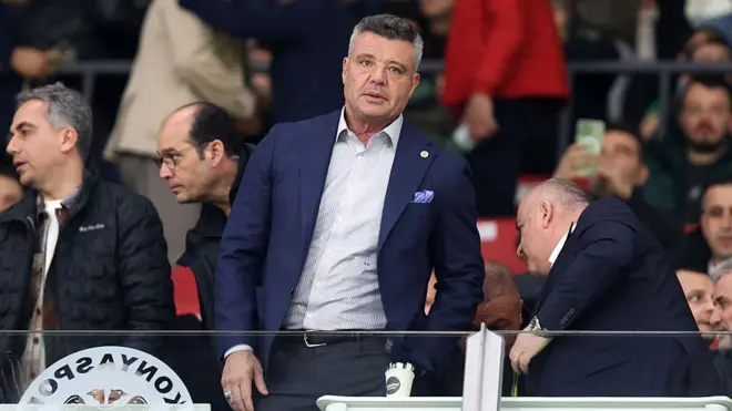 Sadettin Saran Konyaspor tribününde Fenerbahçe maçını izlemek için yerini alırken, üstünde lacivert bir ceket ve açık renkli bir gömlek var