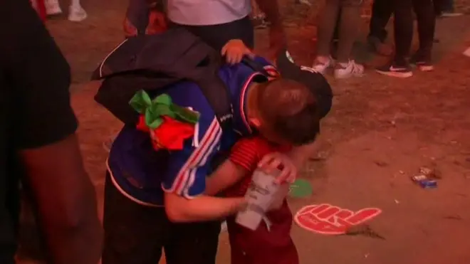 Portuguese boy hugs crying French fan