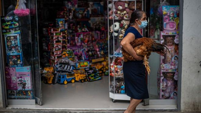 Una mujer carga una gallina en Cajamarca.