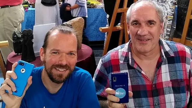 Urs Lesse (à gauche) aide les gens à réparer leurs téléphones