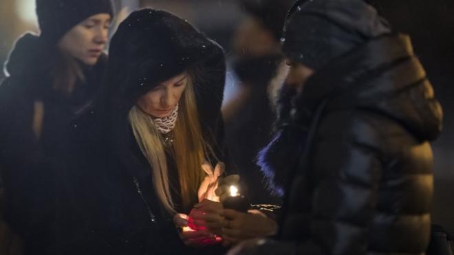 亞歷山德羅夫紅旗歌舞團莫斯科團部外兩名致哀女子點起蠟燭（26/12/2016）