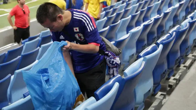 Japanese using bin liners as cheering props before reverting them to rubbish carriers