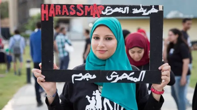 امرأة تحمل لافتة مطالبة بفضح المتحرشين في مصر