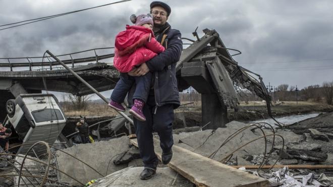 العبور وسط أنقاض جسر مدمر في مدينة إيربين بالقرب من كييف