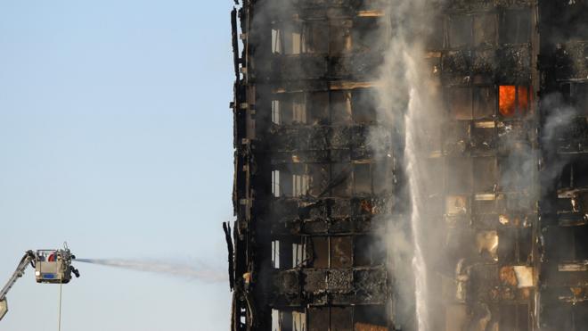 Firefighters continue their efforts to put out the fire, as daylight shows the complete destruction of Grenfell Tower