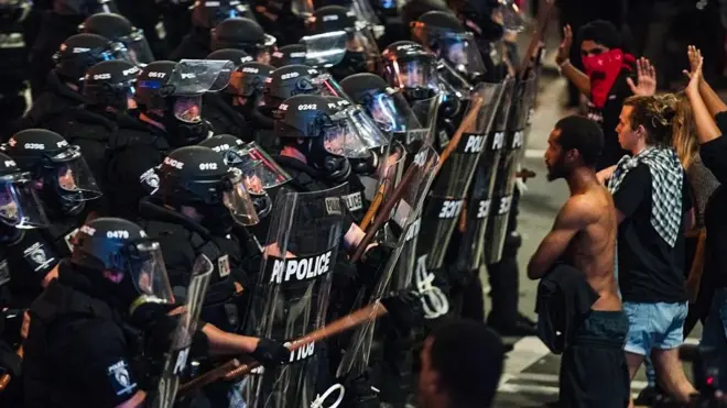 Police officers in riot gear approach demonstrators in downtown Charlotte, North Carolina
