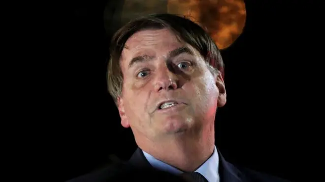 Bolsonaro reacts during a meeting with supporters as he arrives at the official residence in Brasilia, 1 April 2020
