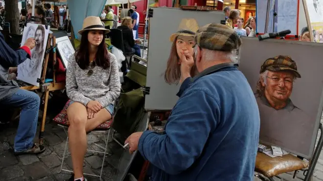 A muchos turistas les gusta que les hagan retratos los artistas que trabajan en las calles del barrio parisino de Montmatre.