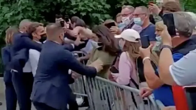 El momento justo después de que el hombre de verde y pelo largo abofeteara a Macron.