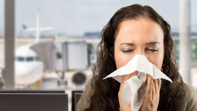 Woman coughing at an airport