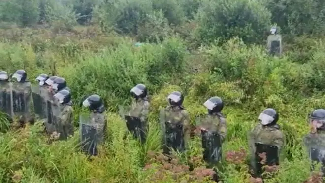 Lithuania's border service released a video showing 12 Belarusian officers armed with shields and riot gear