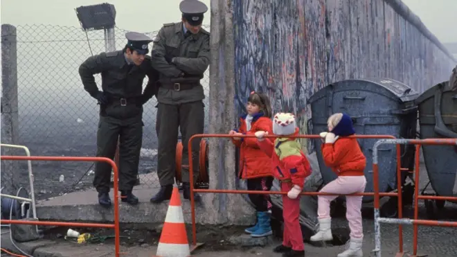 File Photo: West German School Children On The Way To School Come Across The Berlin Wall Being Opened With Two East German Border Guards During The Collapse Of Communism In East Berlin On November 14, 1989. November, 1999 Marks The 10Th Anniversary Of The Fall Of The Berlin Wall. East Germany's Communist Government Erected The Berlin Wall In August 1961. The Wall Fell After Weeks Of Massive Anti-Government Protests On November 9, 1989. The Fall Of The Berlin Wall Is Often Described As The "End Of The Cold War." East German Border Guards Shot 77 People Who Tried To Escape To The West Over The Wall During The Course Of Its Existence. (Photo By Stephen Jaffe/Getty Images)