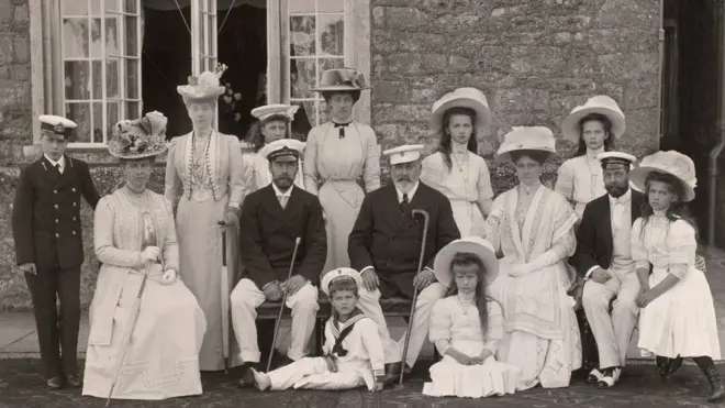 Сделанная 4 августа 1909 г. в приморской резиденции британской королевской семьи на острове Уайт фотография зафискировала последний приезд Романовых в Британию. Слева направо стоят: принц Уэльский Эдвард (будущий король Эдуард VIII и герцог Уиндзорский), королева Александра, дочь будущего короля Георга V принцесса Мария, дочь короля принцесса Виктория и великие княжны Ольга и Татьяна. Сидят: принцесса Уэльская (будущая королева Мария), Николай II, царевич Алексей, король Эдуард VII, великая княжна Анастасия, императрица Александра Федоровна, принц Уэльский (будущий король Георг V) и великая княжна Мария.