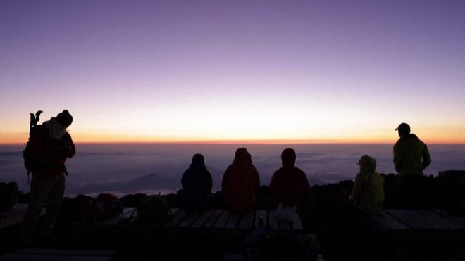 登山客富士山頂等待日出