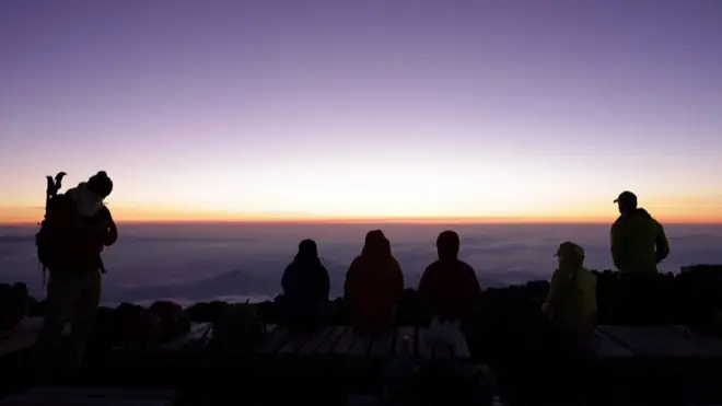 登山客富士山顶等待日出