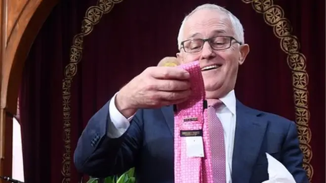 Australian Prime Minister Malcolm Turnbull looks at a Donald Trump branded tie given to him by Pope Tawadros II of Alexandria (left) and Coptic Orthodox Bishop Daniel during his visit to the St Mark Coptic Orthodox Church in Sydney, Australia, 25 June 2017