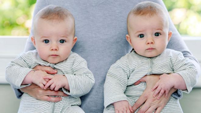 Baby boy twins being held by their mother