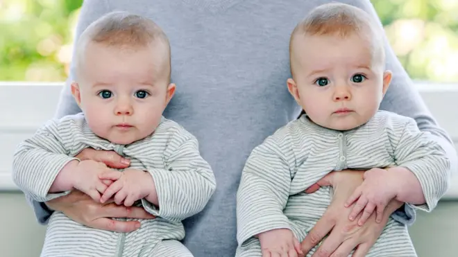 Baby boy twins being held by their mother