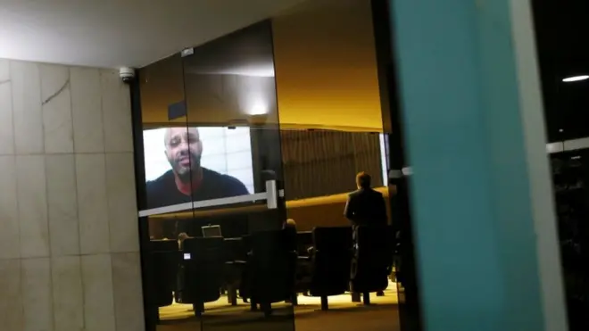 O deputado federal Daniel Silveira aparece falando no telão da Câmara durante sessão em que colegas decidiram mantê-lo preso