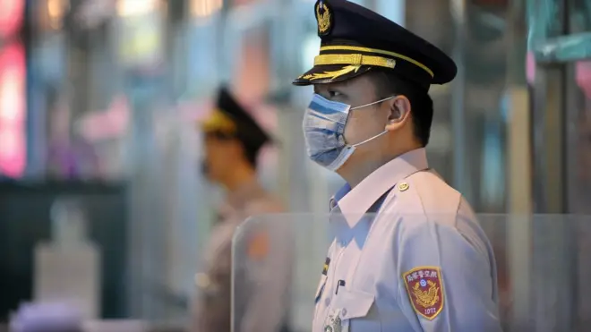Masked policemen stand guard at the entrance of Taoyuan International Airport on April 28, 2009.