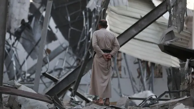 Un hombre observa los destrozos en un edificio en Saná, Yemen, por ataques de EE.UU.
