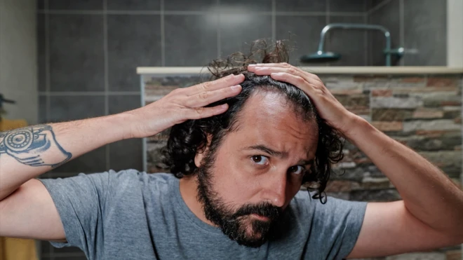 ชายสำรวจผมตัวเอง