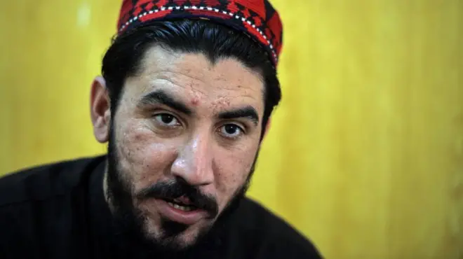 منظور پښتین په خپله ځانګړې خولۍ کې برېښي چې خبرې کوي.