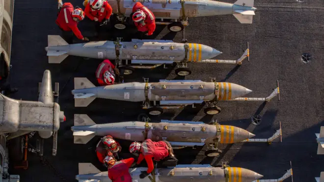 US sailors prepare to stage ordnance on the flight deck of Nimitz-class aircraft carrier USS Abraham Lincoln 