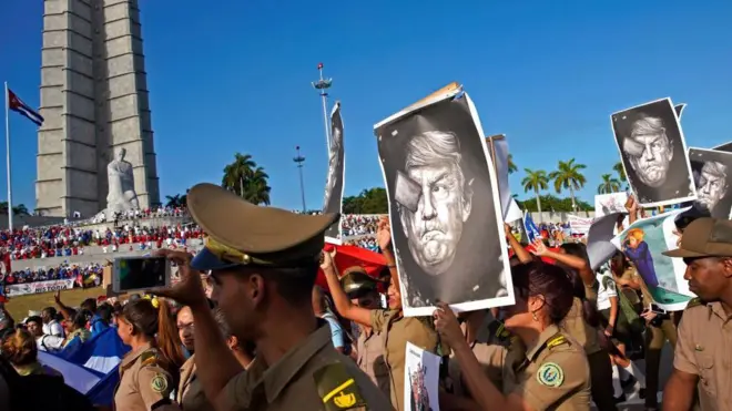 Кубинские военнослужащие несут карикатуры на президента США Дональда Трампа, проходя мимо памятника Хосе Марти во время первомайского парада на площади Революции в Гаване