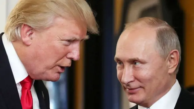 Donald TRump habla con Valdimir Putin, quien le mira con una sonrisa