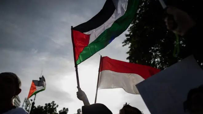 مسيرة تضامنية مع الفلسطينيين أمام السفارة الأمريكية في جاكرتا، إندونيسيا، في 21 مارس/آذار 2025 يظهر فيها العلم الفلسطيني والعلم الإندونيسي