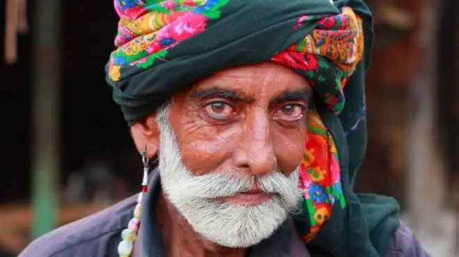 தலையில் தலைப்பாகையுடன் இருக்கும் ஒரு நபர்