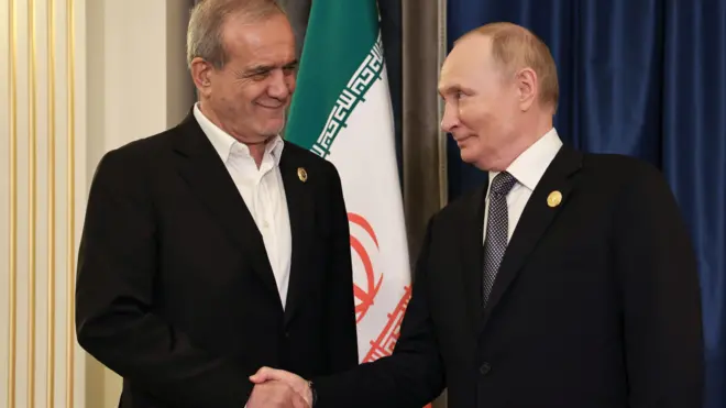 El presidente de Irán, Masoud Pezeshkian, y el presidente de Rusia, Vladimir Putin,, se dan la mano antes de una reunión en el marco de la cumbre de la Organización de Cooperación de Shanghái, China, el 1 de septiembre 2025 