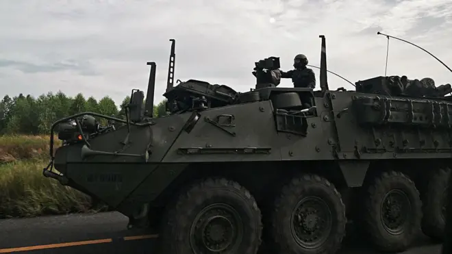 Seorang tentara naik kendaraan berat.