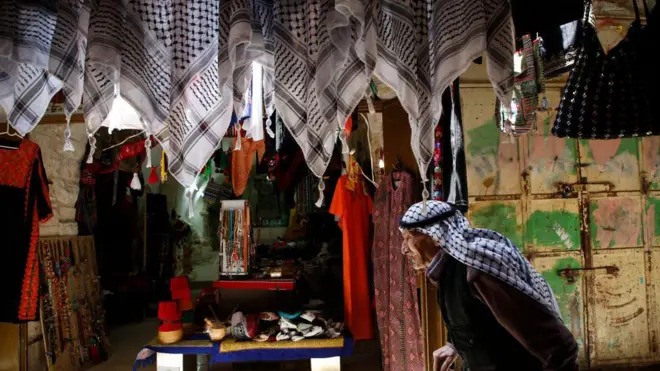 رجل فلسطيني مسن يسير في البلدة القديمة في مدينة الخليل بالضفة الغربية المحتلة.