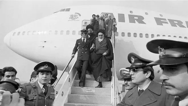 Aiatolá Ruhollah Khomeini desce do avião da Air France que o trouxe de volta a Teerã