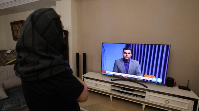 زنی مقابل اخبار تلویزیون ایران در شب حمله به اسرائیل