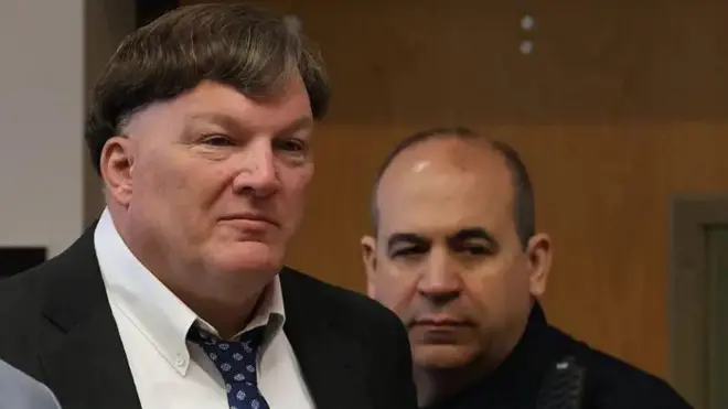 Фото чоловіка у костюмі, на задньому плані інший чоловік - поліцейський