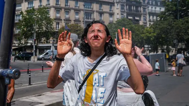 Un joven se refresca en París.