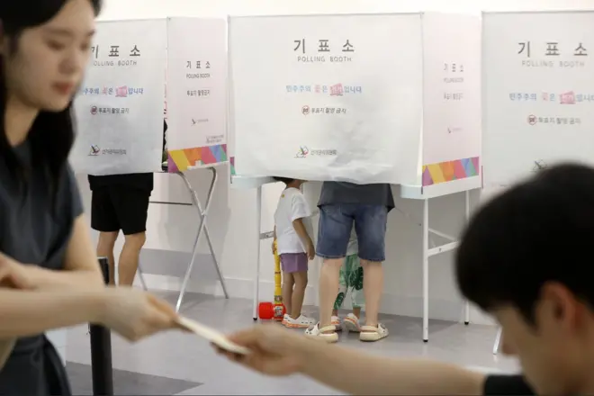 제9회 전국동시지방선거 및 국회의원 재·보궐선거일인 3일 부산 부산진구청에 마련된 부암제1동제4투표소에서 아이들이 엄마가 투표하는 모습을 지켜보고 있다