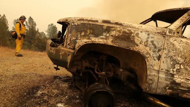 : A Redding firefighter looks on as the Carr Fire moves through the area on July 28, 2018 in Redding, California.
