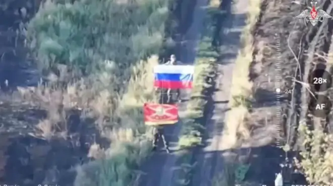 Ifoto itaboneka neza y'abagabo babiri bafite amabendera y'Uburusiya mu muhanda - rimwe muri ayo mabendera rifite amabara atatu, irindi ni ibendera ritukura ry'igisirikare.