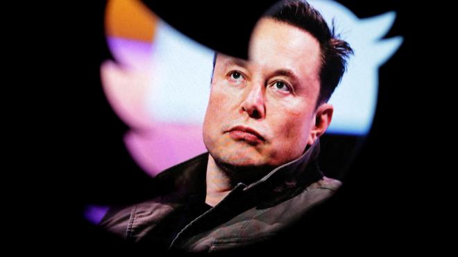 Elon Musk, visto a través de una silueta con la forma del logo de Twitter